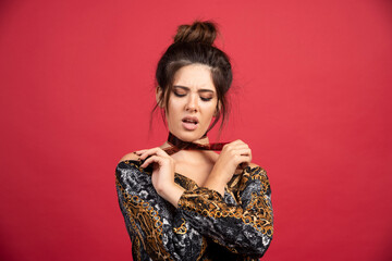 Brunette girl ties a polaroid photo film to her neck