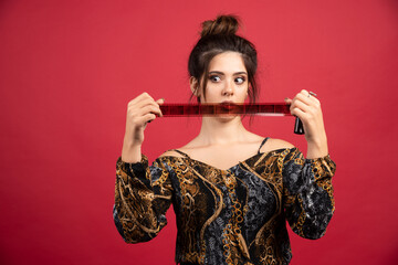 Brunette girl checks her photo history on polaroid film and thinking about new posing ideas