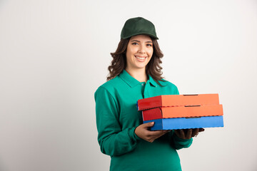 Delivery woman with pizza boxes posing on white background