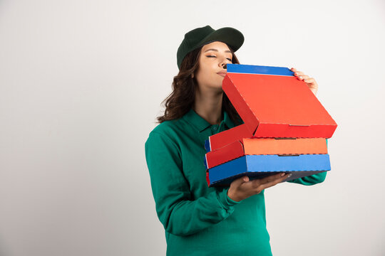 Delivery woman hungrily smelling pizza
