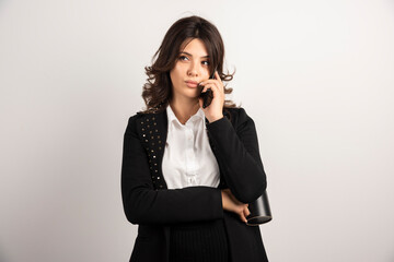 Woman employee talking on telephone on white background