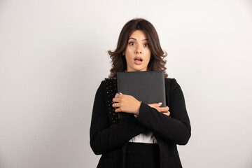 Fototapeta premium Female teacher holding a book with shocked expression