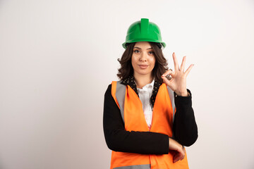 Woman industrial worker showing ok sign on white background