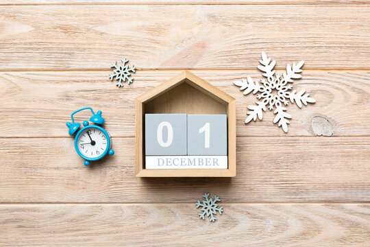 Christmas wood calendar with new year decorations, aganist colored background. Christmas calendar 1 december