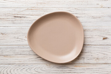 Top view of empty pink plate on wooden background. Empty space for your design