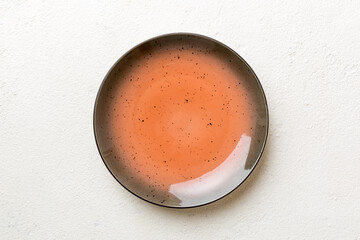 Top view of empty red plate on cement background. Empty space for your design