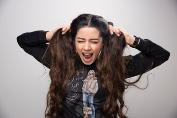 Young girl in printed sweatshirt pulling her hair out of frustration