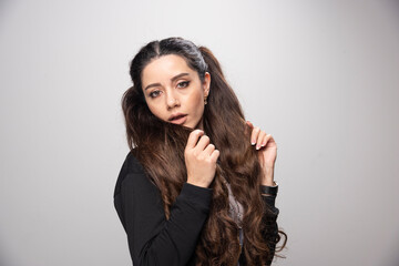 Fototapeta premium Long haired girl in black sweatshirt looking at camera