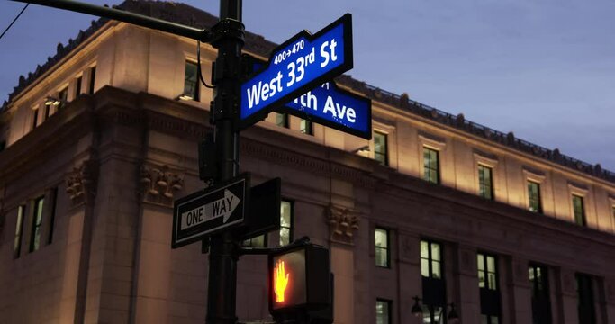 new York City at night, Street and Avenue signs above Pedestrian Traffic Light. Twilight in Manhattan.