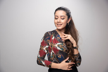 Young beautiful woman in colorful blouse smiling with closed eyes