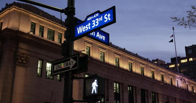 Road signs in Manhattan, NYC. West 33rd Street and pedestrian traffic light at night in new York City