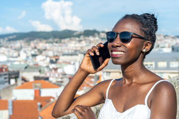 Woman using a phone on a hot day Blurred city view background.