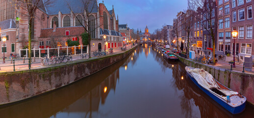 Beautiful old houses on the city waterfront of Amsterdam at dawn.