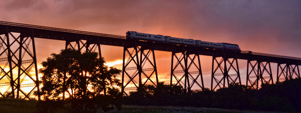 Train crossing a bridge at sunset