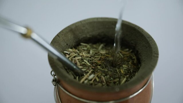 Argentina traditional infusion. Closeup view of a mate drink with yerba herbs and hot water. 