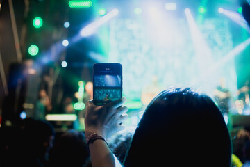 Persona grabando con su teléfono un concierto de música. Concepto de entretenimiento y viajes.
