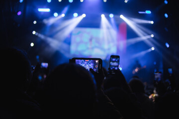 Persona grabando con su teléfono un concierto de música. Concepto de entretenimiento y viajes.