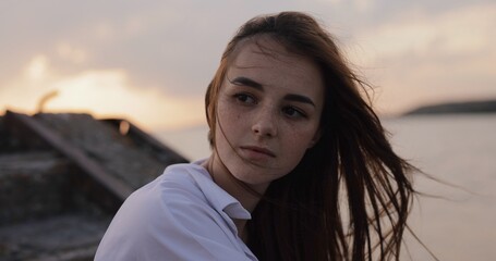 Young cute woman portrait sitting on the pier at evening - 515941439