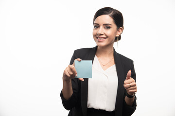 Female employee holding memo pad and giving thumbs up