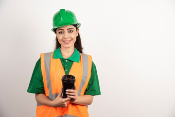 Smiling female constructor with black cup