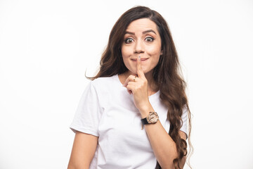 Young pretty woman in white shirt making silence sign
