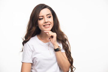 Wavy haired woman in white shirt posing on white background