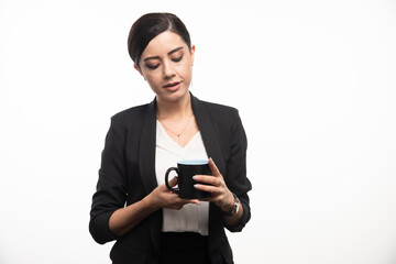 Businesswoman looking on a black cup on a white background