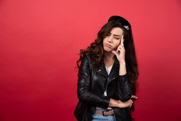 Young woman posing with black glasses on a red background