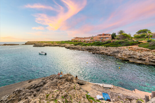 Sunset at the rocky coastline along the Mediterranean Sea at the Spanish town of Binebaca Vell on the island of Menorca, Spain.