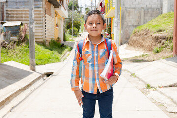 Happy Hispanic boy ready to go to school with his backpack and notebooks - Latin boy on his way to...