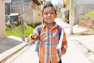 Happy Hispanic boy with thumb up ready to go to school with his backpack and notebooks - Latin boy...