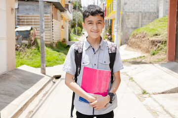 Happy Hispanic boy ready to go to school with his backpack and notebooks - Latin boy on his way to school - Happy boy in town