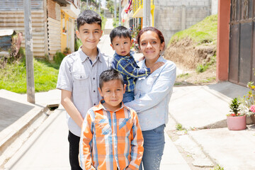Young mother with her children happy outside her house in rural area-Hispanic family-single mother with three children