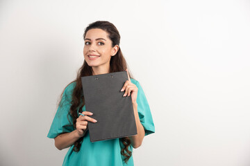 Fototapeta premium Young nurse with clipboard and pencil