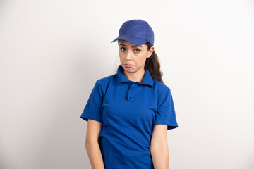 Pretty woman in blue uniform touch her face with hand