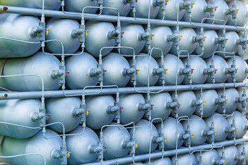 A lot of bottles filled with gas or gasoline are stacked in piles