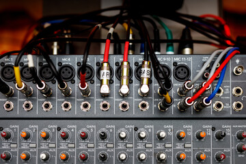 The audio jacks are connected to the sound mixer. Wires and cables at music studio.