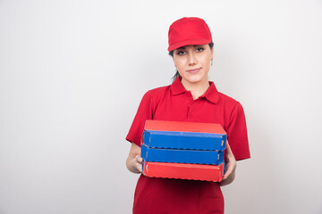 Female courier carrying boxes of pizza on white background