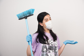 Woman posing with facemask and mop on white background
