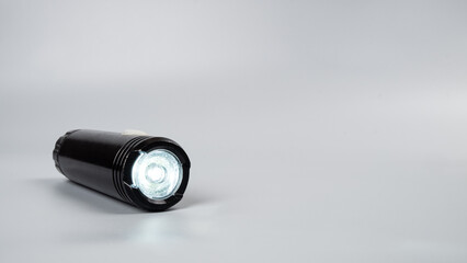 led flashlight on gray background with copy space.