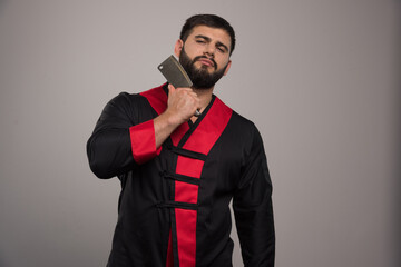 Young man shaving his beard with sharp knife