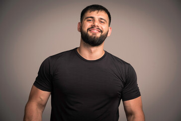 Sportive man in black shirt looks confident and smiling