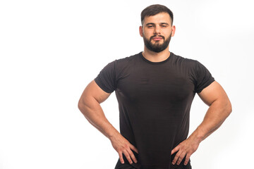 Sportive man in black shirt showing his fit body