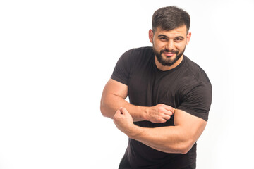 Sportive man in black shirt showing his biceps