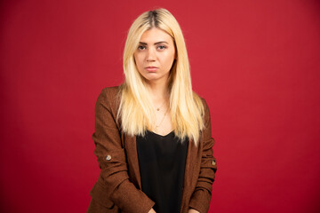 Fototapeta premium Businesswoman in casual outfit standing on red background