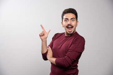 Fototapeta premium A happy brunette man showing a finger up and posing