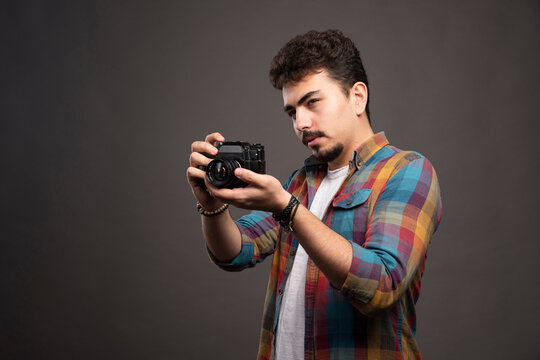 Young experienced photograph taking professional photos in a serious manner