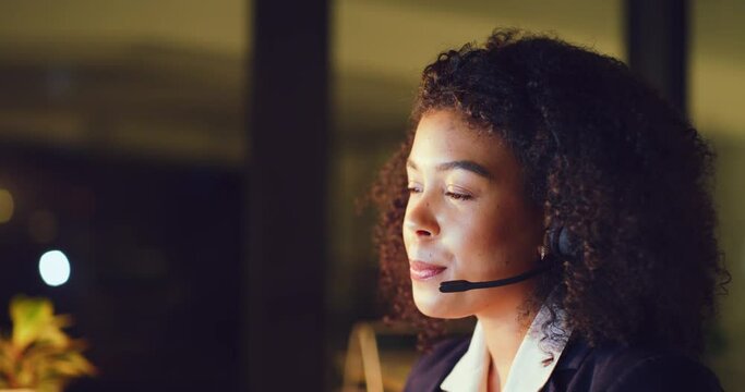 Young female call center agent consulting with clients while working late in an office alone. One black female helpdesk worker having a conversation with a customer and doing overtime in the dark