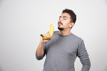 A young man holding two fresh bananas