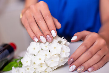 Obraz na płótnie Canvas Close up view of beautiful female hands with luxury manicure nails, pink and white gel polish 